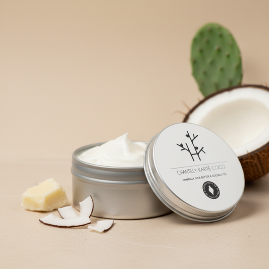 Chantilly karité et coco Le Figuier d’Orient présentée pot ouvert, laissant apparaître une texture fouettée onctueuse et blanchâtre. Soin naturel nourrissant pour la peau et les cheveux, mis en scène avec des ingrédients naturels comme le beurre de karité, la coco et la figue de barbarie, dans un décor épuré et haut de gamme.