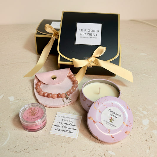 Coffret cadeau bien-être composé d’une bougie parfumée, d’un baume à lèvres naturel et d’un bracelet, présenté dans un écrin élégant. Coffret Le Figuier d’Orient, cosmétique naturel, idée cadeau raffinée et sensorielle pour Noël.