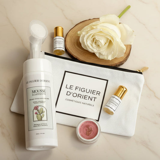 Coffret Éclat d’Orient du Figuier d’Orient comprenant la mousse nettoyante démaquillante anti-âge à la rose de Damas avec brosse intégrée, un baume à lèvres naturel gourmand à la cerise, un mini parfum musc Rêve Gourmand et une trousse élégante, présenté dans une ambiance douce, naturelle et raffinée.