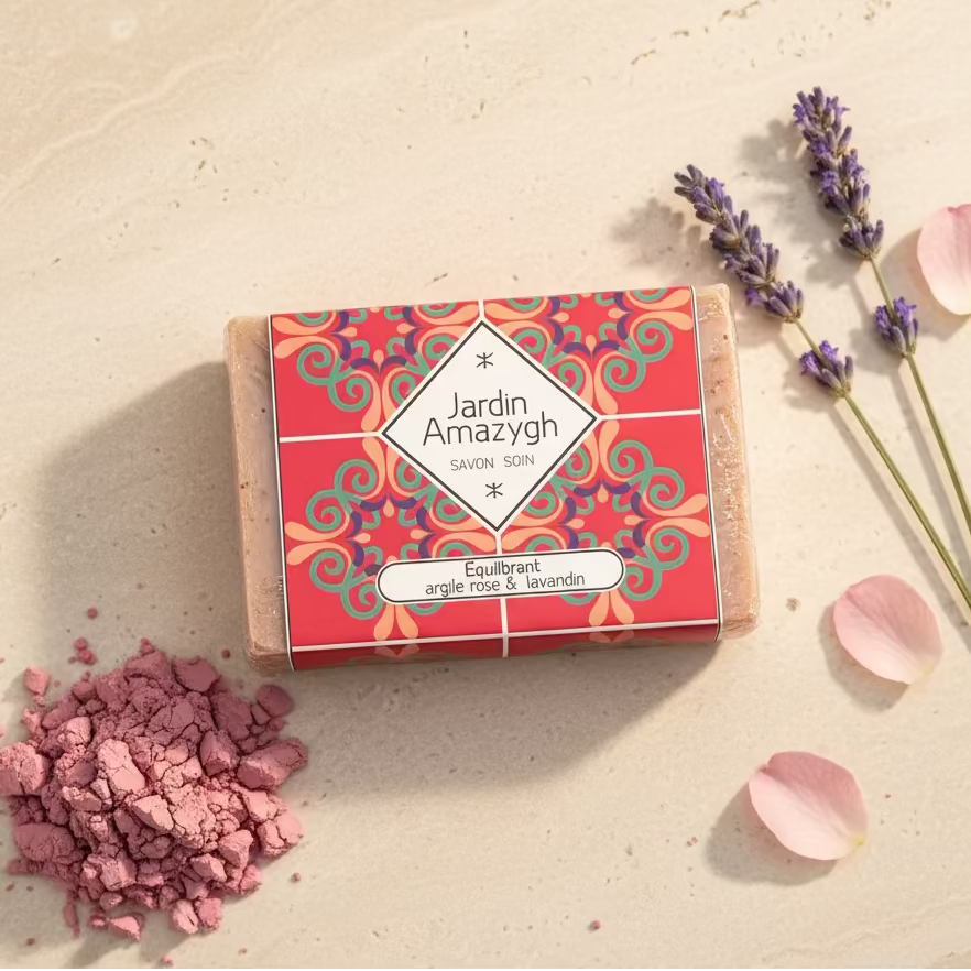 Photographie produit haut de gamme en format carré (1:1), ultra réaliste, lumière naturelle douce et chaleureuse.
Le savon “Équilibrant – Argile Rose & Lavandin” Jardin Amazygh doit être parfaitement centré, bien net, étiquette totalement lisible, couleurs fidèles à l’original.
Fond minéral beige sable clair, texture pierre naturelle très subtile et élégante.
Décoration minimaliste et harmonieuse :
– Une petite touche d’argile rose en poudre, déposée de manière délicate et maîtrisée (pas éparpillée)
– Deux