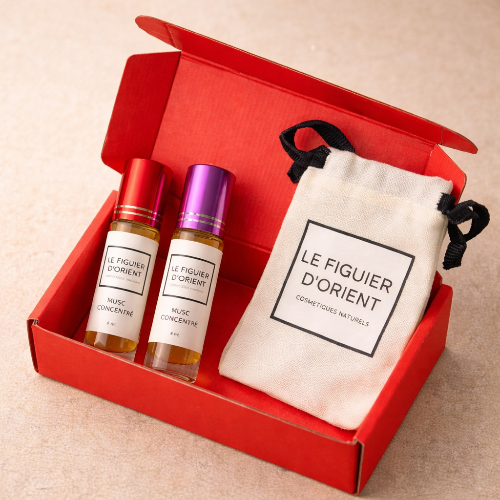 Coffret rouge Le Figuier d’Orient contenant deux muscs concentrés 8 ml roll-on avec bouchons rouge et violet et pochette en coton naturelle – parfum de niche suisse.
