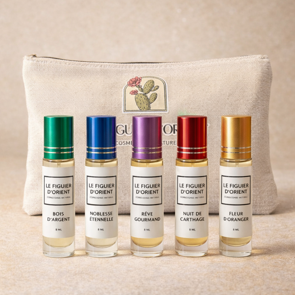 Coffret signature Le Figuier d’Orient avec 5 muscs concentrés 8ml (Bois d’Argent, Noblesse Éternelle, Rêve Gourmand, Nuit de Carthage, Fleur d’Oranger) présentés devant la trousse en coton naturel – maison suisse de parfums de niche.