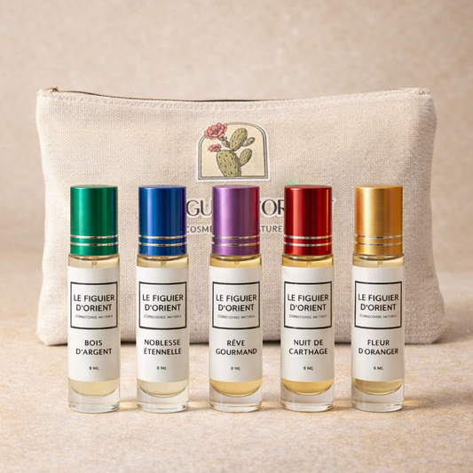 Coffret signature Le Figuier d’Orient avec 5 muscs concentrés 8ml (Bois d’Argent, Noblesse Éternelle, Rêve Gourmand, Nuit de Carthage, Fleur d’Oranger) présentés devant la trousse en coton naturel – maison suisse de parfums de niche.