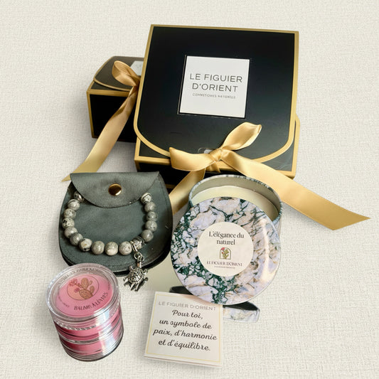 Coffret cadeau bien-être naturel Le Figuier d’Orient comprenant une bougie parfumée élégante, un bracelet symbolique et un baume à lèvres nourrissant, présentés dans un coffret raffiné prêt à offrir. Idéal comme cadeau de Noël ou attention bien-être de dernière minute, aux textures sensorielles et à l’univers élégant et naturel.