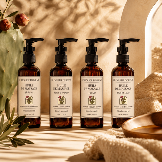 Quatre huiles de massage naturelles Le Figuier d'Orient aux senteurs Fleur d'oranger, Thé Vert, Vanille et Miel & Coco, présentées dans un décor inspiré des rituels de bien-être orientaux.