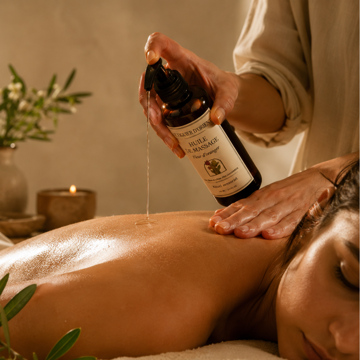 Huile de massage naturelle Le Figuier d'Orient utilisée lors d'un massage relaxant, avec l'huile délicatement versée sur la peau pour nourrir, assouplir et sublimer le corps dans un rituel de bien-être inspiré des traditions orientales.