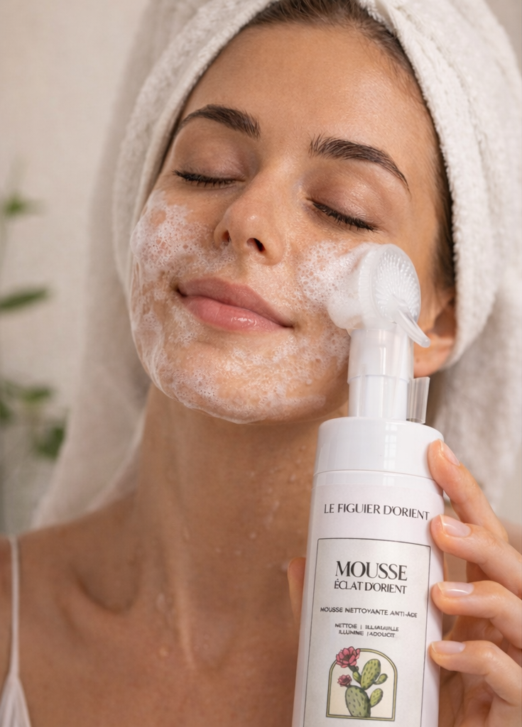 Femme appliquant la mousse nettoyante anti-âge Le Figuier d’Orient à la figue de barbarie, nettoyage du visage avec brosse intégrée, rituel de beauté naturel visage